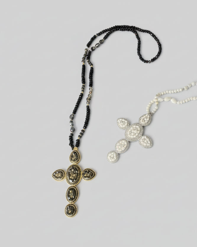 Détail pendentif croix noir et doré sur collier sautoir femme