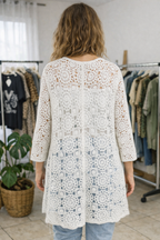 Dos d’un gilet long blanc en crochet motif bohème chic