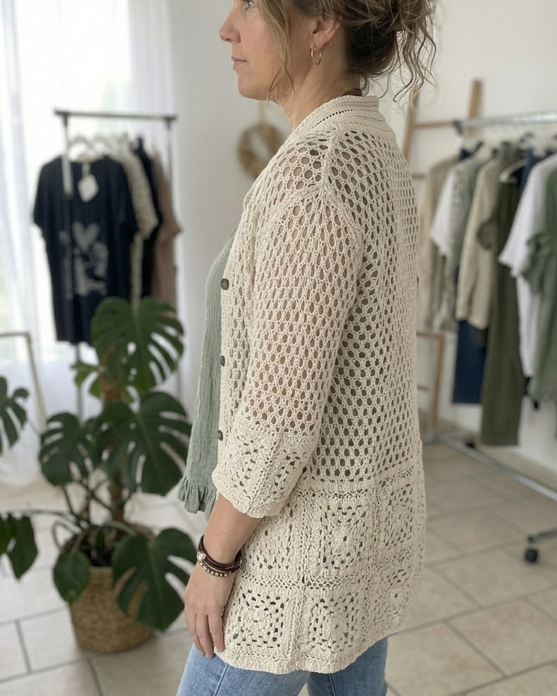 Ensemble bohème femme : gilet long en crochet crème ouvert sur une blouse fluide verte gaufrée.