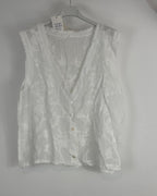 Blouse sans manches bohème en coton brodé, tissu léger et détails ton sur ton, présentation sur cintre