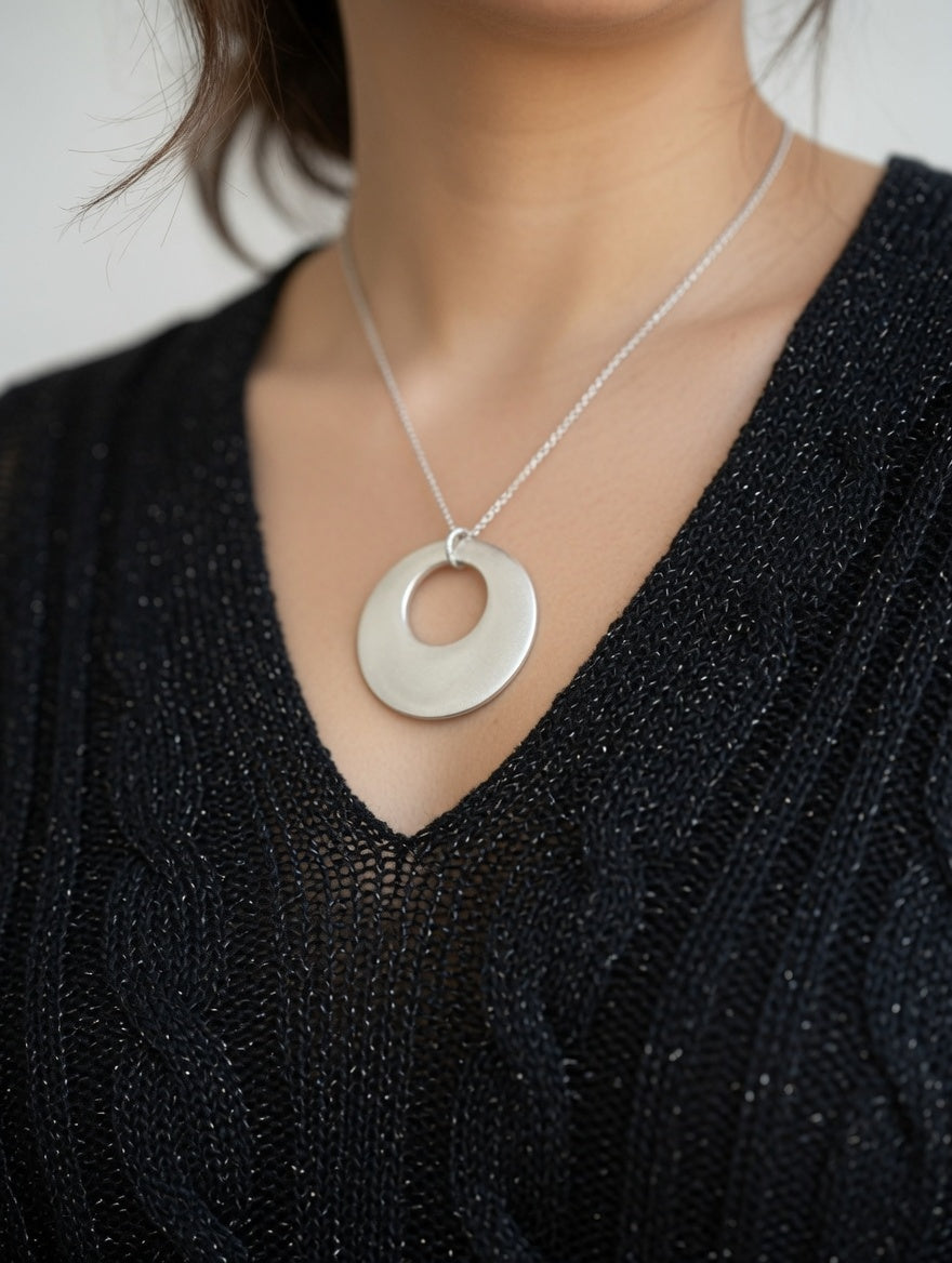 Haut noir femme en maille, détail des fils argentés discrets et texture souple du tissu