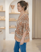 Vue de profil d'une tunique évasée à manches papillon et motifs ikat, look printanier décontracté.