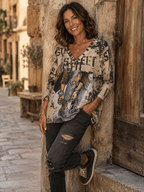 Femme portant le haut Stella Girl Street beige imprimé avec jean gris dans une ruelle italienne