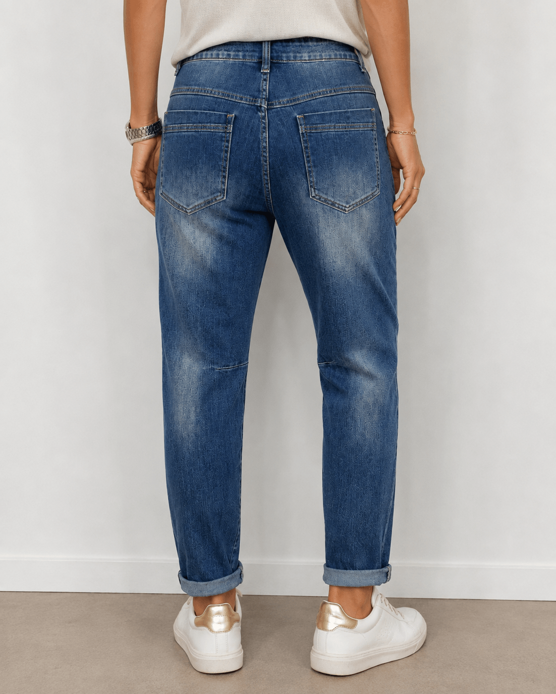 Vue portée de dos du jean Amore S.Woman en denim bleu avec poches arrière et effet délavé, baskets blanches à détails dorés
