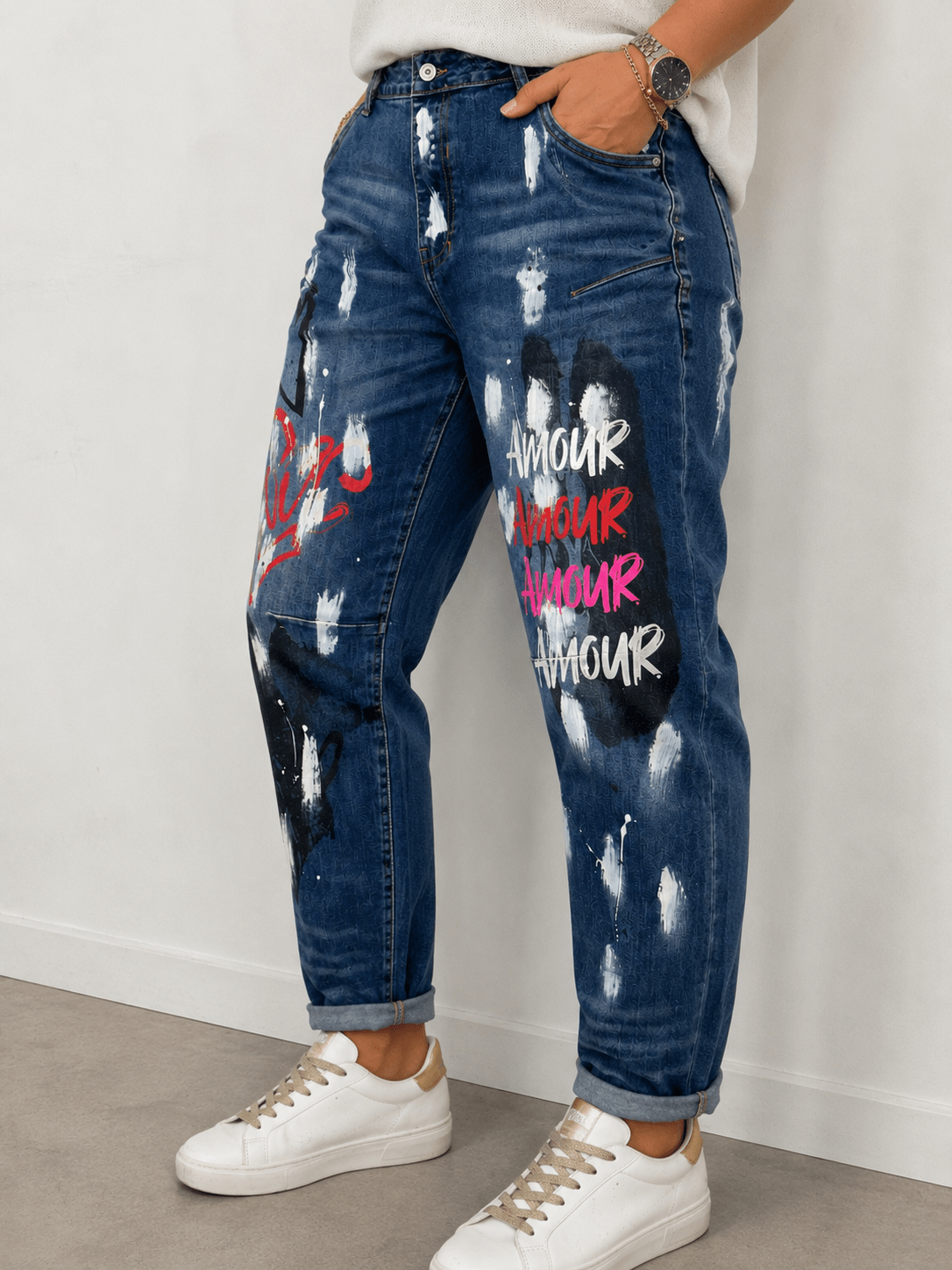Jean Amore S.Woman porté de trois quarts avec gros plan sur les inscriptions Amour multicolores et les effets peinture du denim