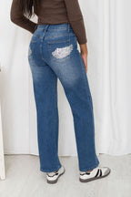 Vue source du jean Angel bleu délavé, jambes larges et ailes argentées aux poches arrière