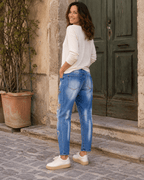 Vue trois quarts dos du jean Brera S.Woman boyfriend délavé avec poches arrière dans une ruelle italienne