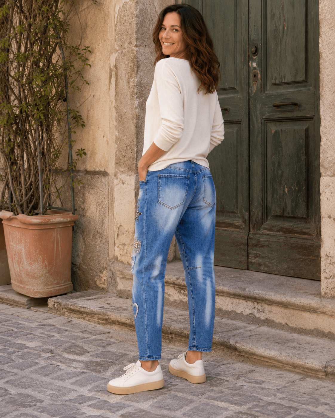 Vue trois quarts dos du jean Brera S.Woman boyfriend délavé avec poches arrière dans une ruelle italienne