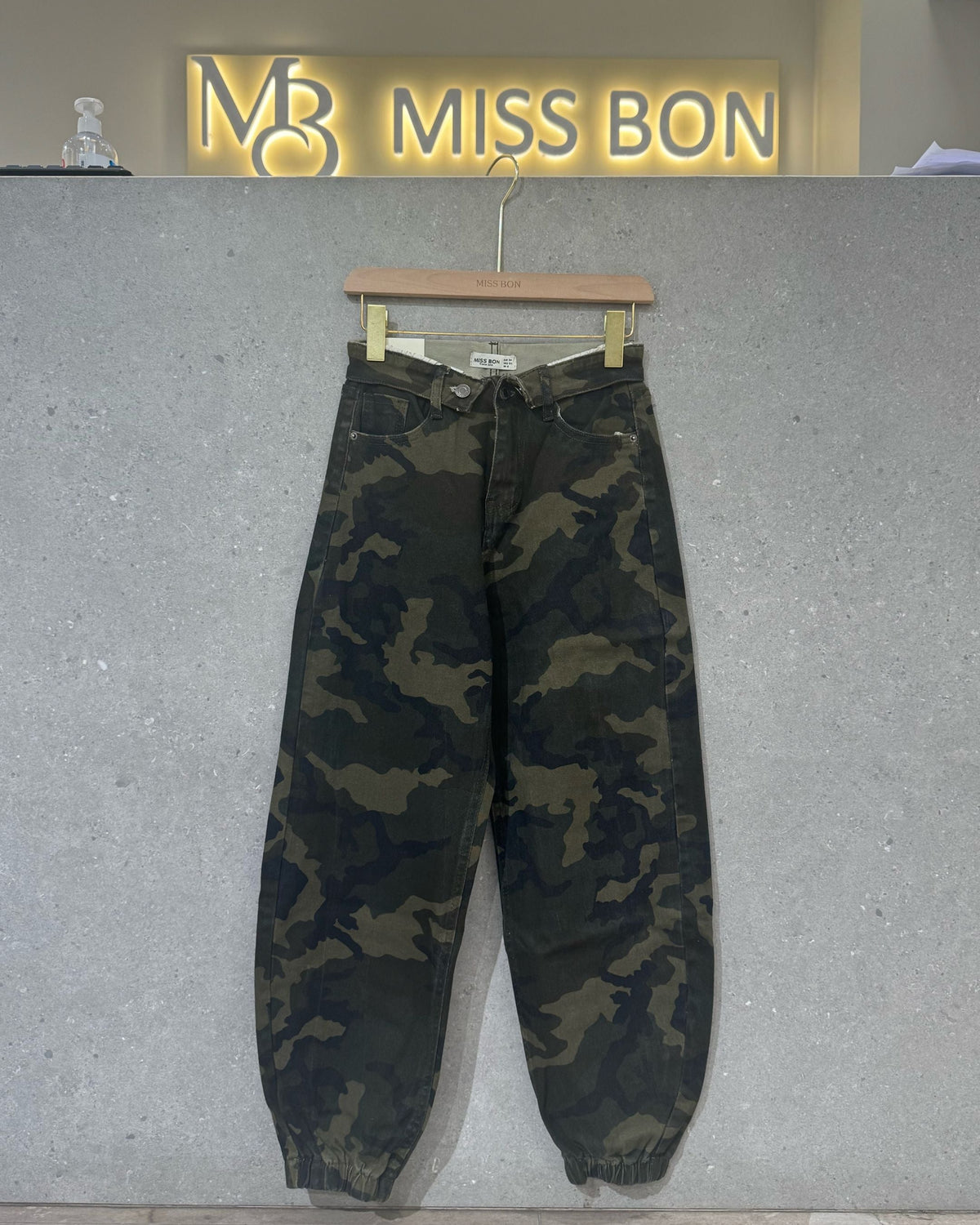 Photo réelle du jean Charlie camouflage sur cintre, coupe ample et bas de jambes élastiqués