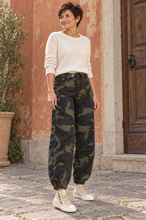 Femme aux cheveux courts portant le jean Charlie camouflage avec un pull écru et les baskets Amour beiges