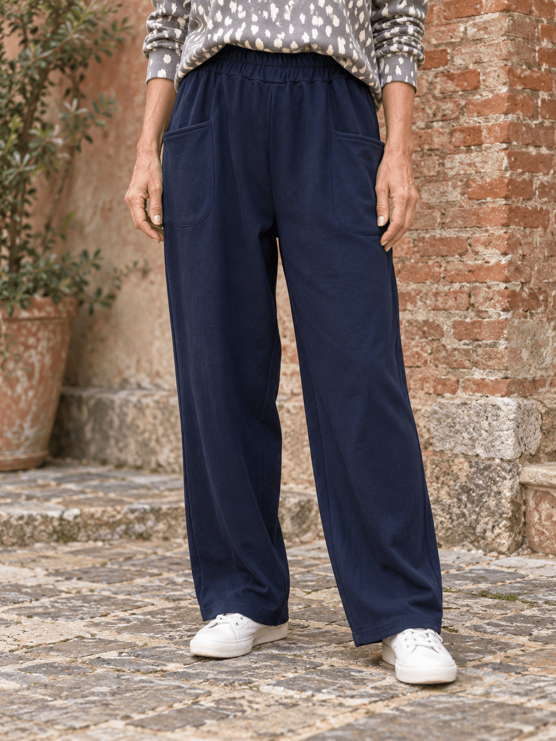 Jogging Nora marine porté de face, grandes poches plaquées et taille élastiquée sans cordon. (Mise en scène IA.)