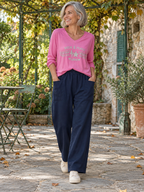 Jogging Nora marine en silhouette entière avec le pull Stella rose bonbon. (Mise en scène IA.)