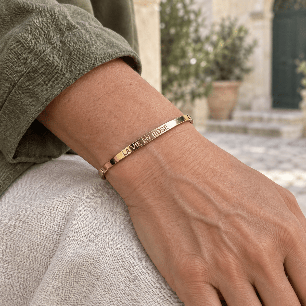 Bracelet jonc La vie en rose – Acier inoxydable doré porté, vue rapprochée.