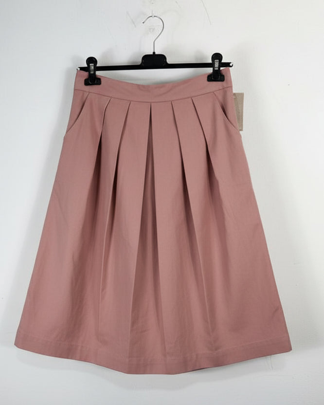 Jupe plissée mi-longue rose vieux sur cintre, détail des plis et de la ceinture structurée