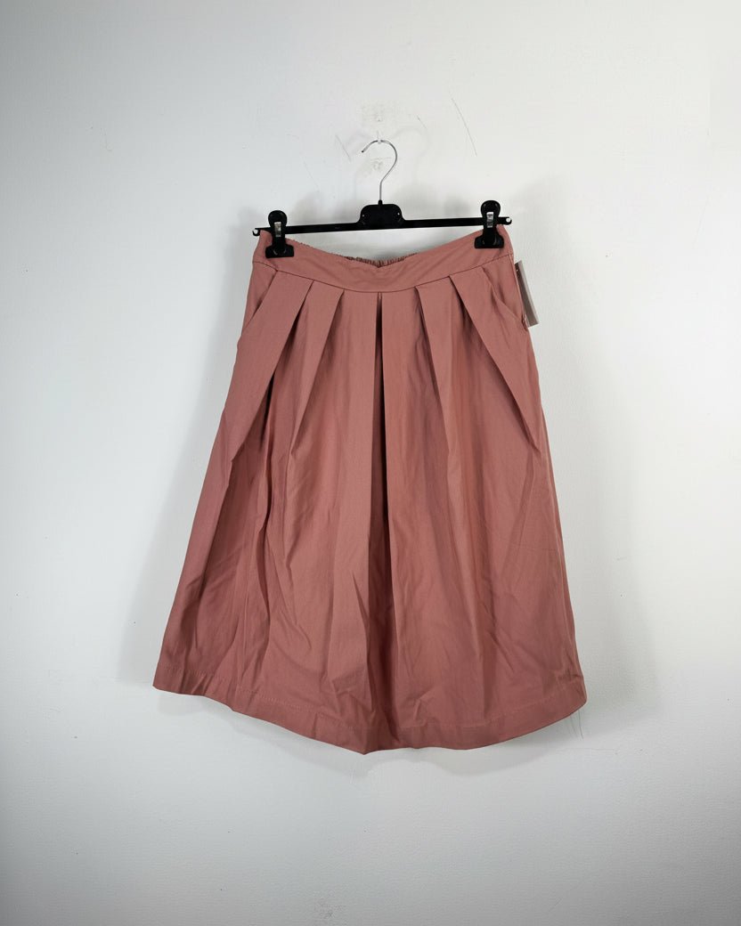 Jupe plissée mi-longue rose vieux sur cintre, détail des plis et de la ceinture structurée