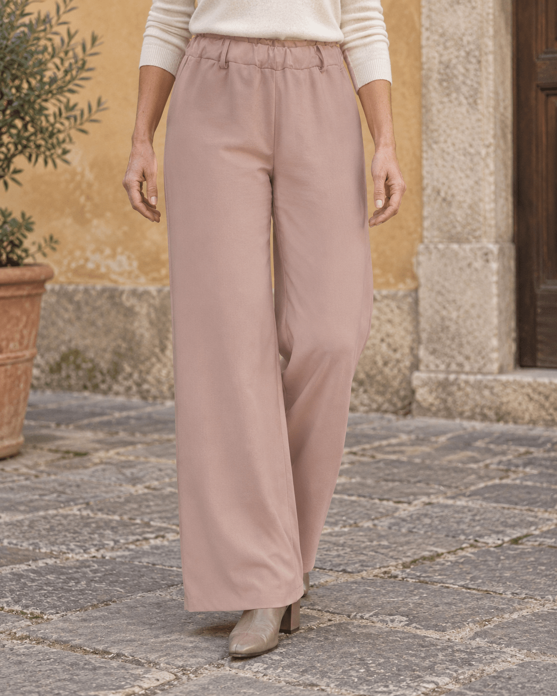 Pantalon chino rose poudré porté, cadrage sur la taille élastique et les jambes larges