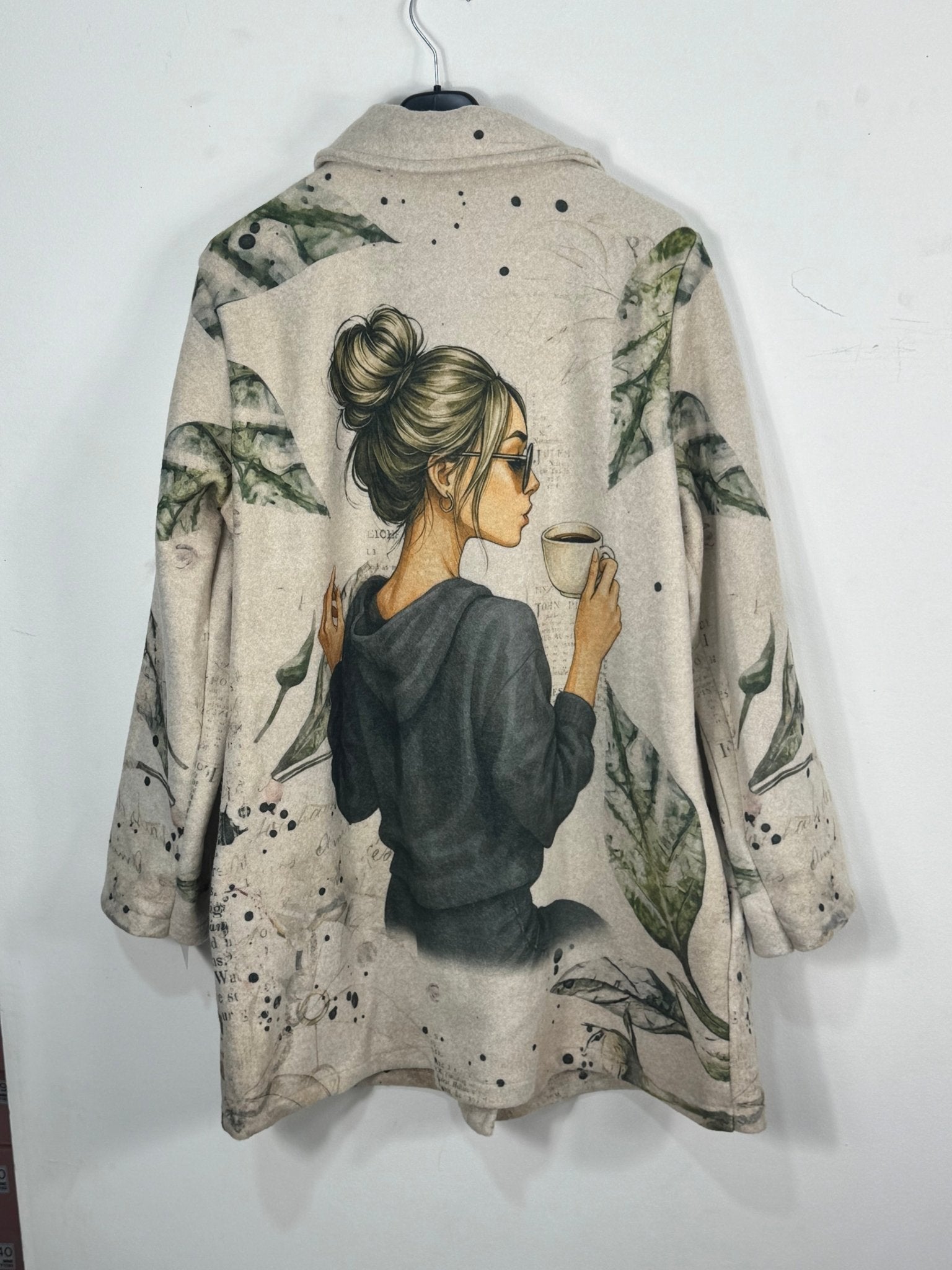 Dos réel du manteau Paola beige avec grande illustration femme au café et feuillage vert