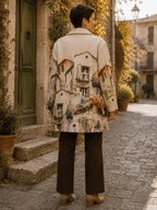 Dos du manteau Toscana à imprimé village provençal porté par Sofia dans une rue pavée