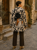 Dos du manteau Valentina beige et noir à imprimé graphique porté par Sofia dans une rue italienne