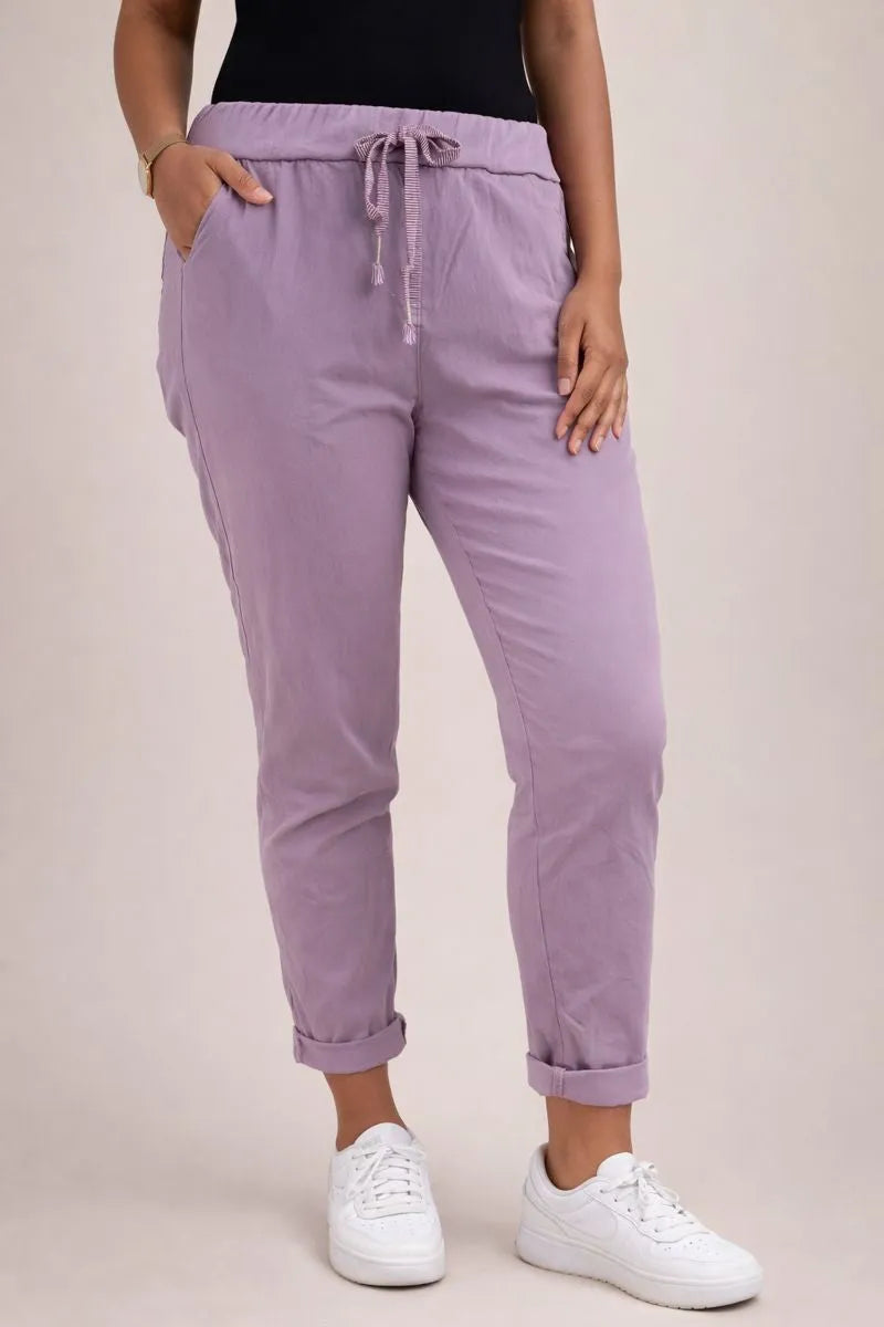 Pantalon grande taille lilas pour femme, coupe fluide et taille élastique, parfait pour un look casual chic en boutique.
