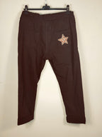 Pantalon magique Étoile chocolat de dos sur cintre, avec deux poches plaquées et une étoile léopard.