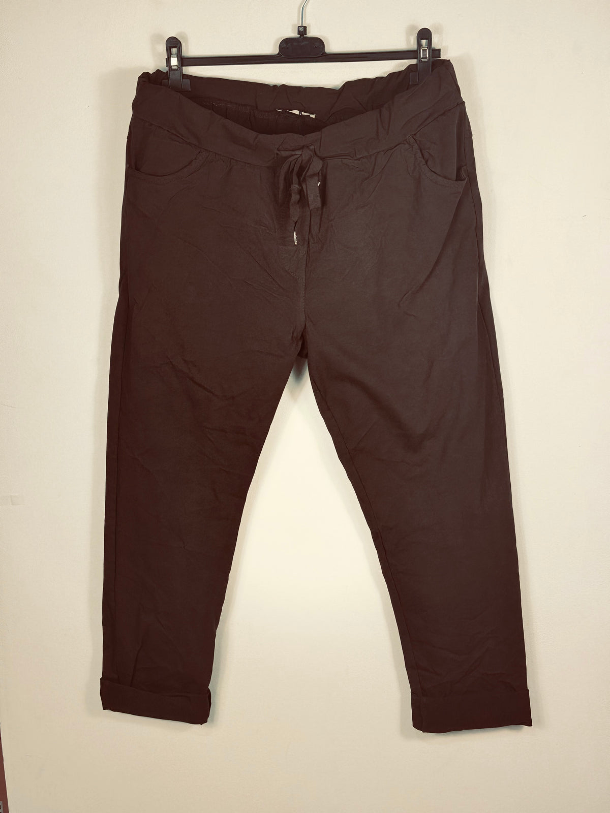 Pantalon magique Étoile chocolat sur cintre, vue de face et lien de taille à embouts métalliques.