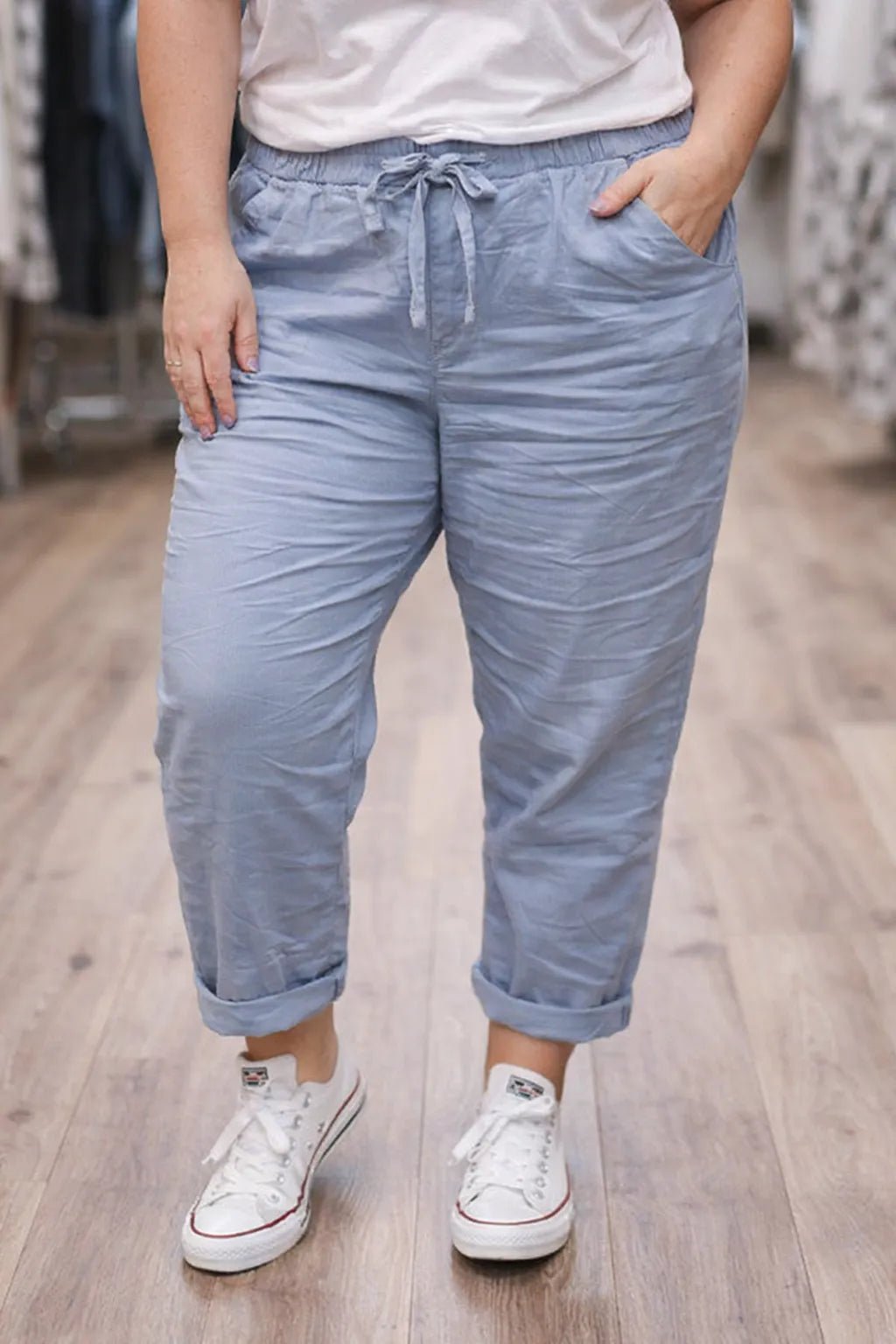 Pantalon Magique bleu jean porté avec des baskets, coupe droite et cordon de serrage