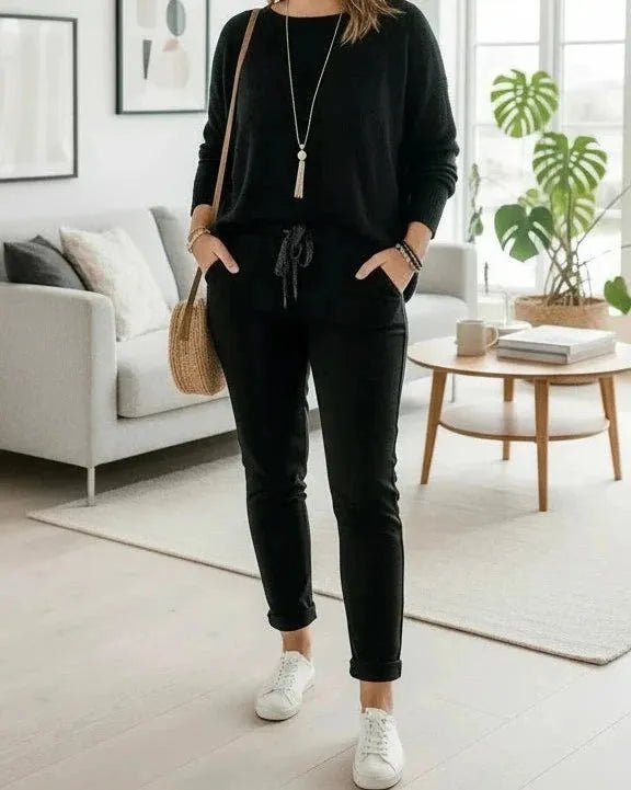 Pantalon Magique noir porté en intérieur, silhouette élégante et matière extensible