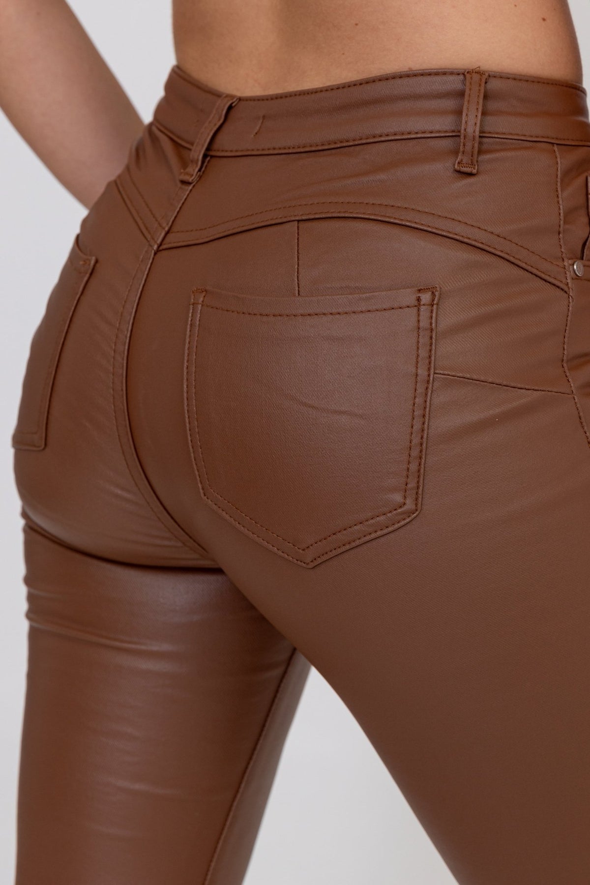 Détail du dos du pantalon simili cuir chocolat : poche plaquée, coutures et passants de ceinture.
