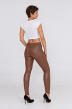 Sofia portant le pantalon ajusté en simili chocolat, vue dos.