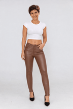 Sofia portant le pantalon ajusté en simili chocolat, vue face.
