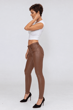 Sofia portant le pantalon ajusté en simili chocolat, vue profil.
