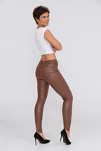 Sofia portant le pantalon ajusté en simili chocolat, vue trois quarts dos.