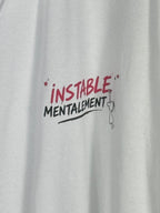 Détail du motif Instable mentalement framboise et noir sur le coton blanc du polo.