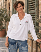 Femme aux cheveux courts portant le polo Instable blanc à deux boutons et manches longues avec le jog-jean Torino.