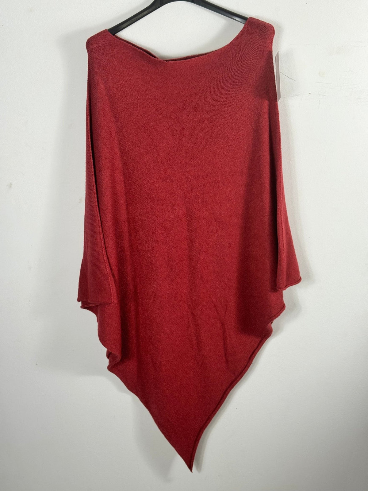 Photo d’origine du poncho asymétrique rouge sur cintre.