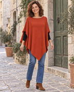 Femme portant le poncho terracotta sans foulard, vue en pied montrant son encolure et son devant en pointe.