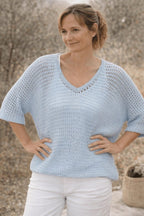 Pull ajouré bleu ciel vue porté avec pantalon blanc 
