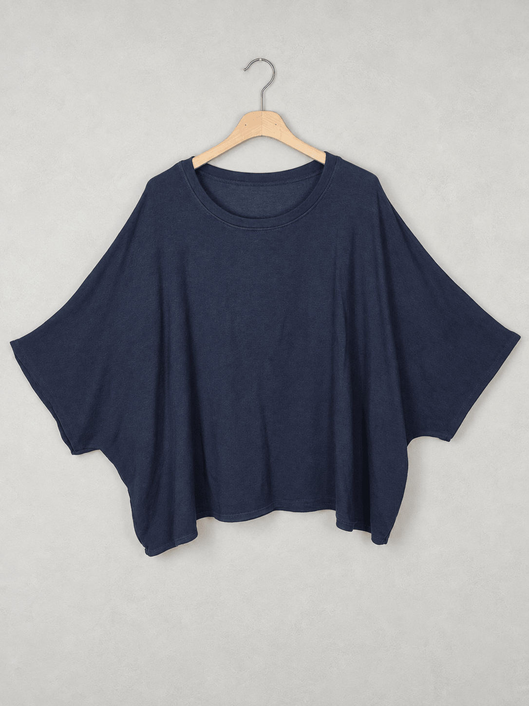 Pull marine sur cintre, encolure ronde et large coupe chauve-souris.