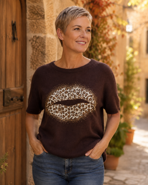 Femme portant le pull Bacio chocolat à bouche léopard et strass avec un jean dans une ambiance italienne
