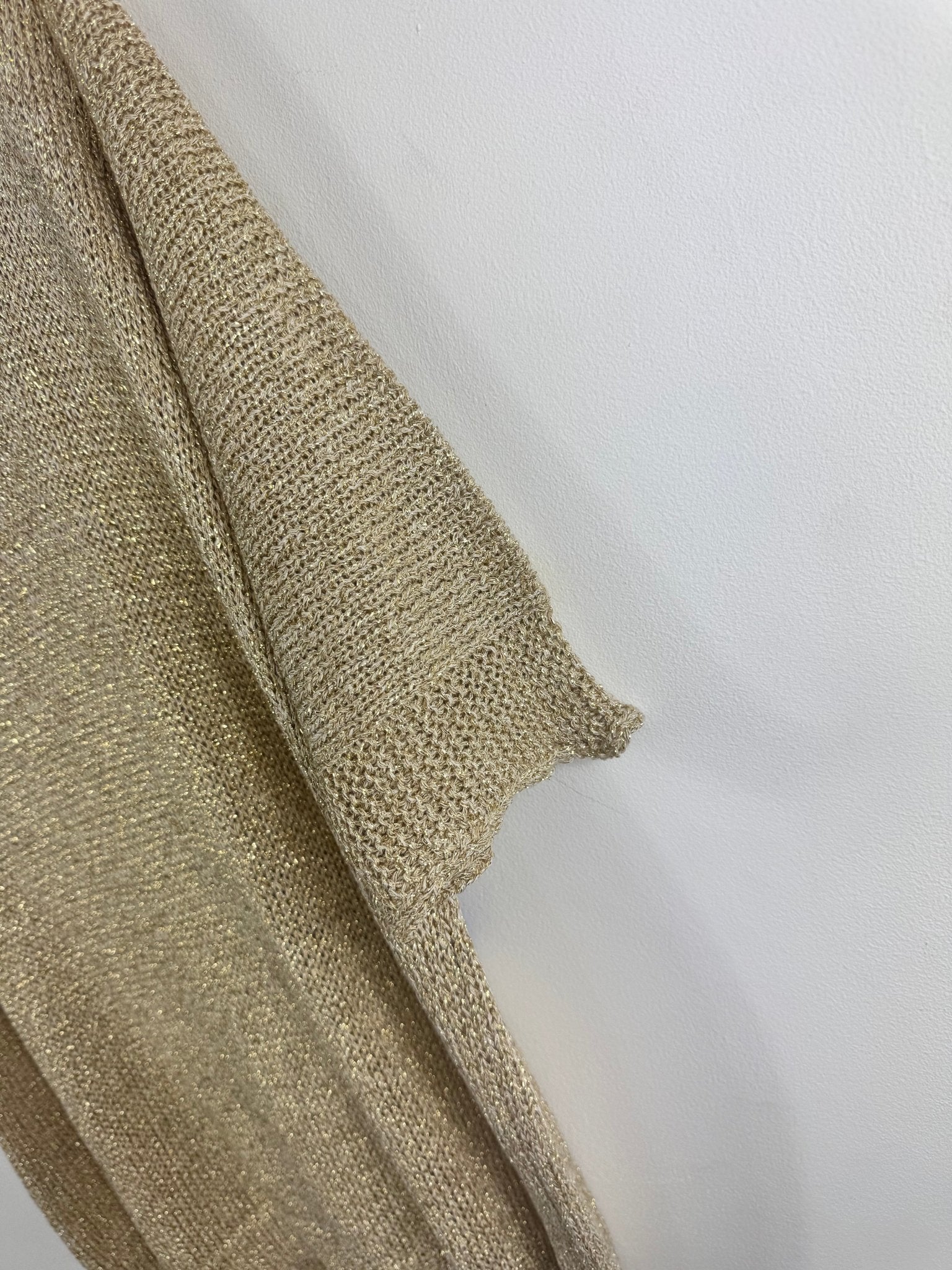 Détail réel de la manche courte et de la maille lurex dorée du pull Bella