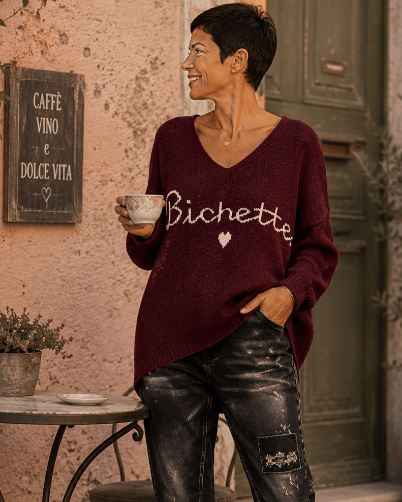 Pull Bichette lie de vin porté avec pantalon noir sur une terrasse italienne
