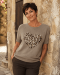 Femme portant le pull Cuore taupe à cœur léopard et strass avec pantalon chocolat dans une ruelle italienne