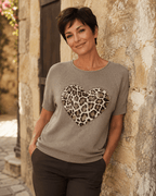 Femme portant le pull Cuore taupe à cœur léopard et strass avec pantalon chocolat dans une ruelle italienne