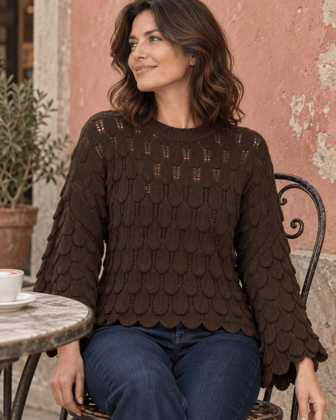 Pull Élise chocolat porté, maille écailles et manches cloche à une terrasse italienne
