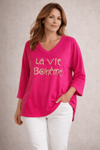 Pull fushia femme col V message doré La Vie Bohème, look moderne pantalon blanc