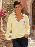 Sofia portant le pull Lucia jaune clair, col V à liseré brillant et petit motif LOVE rose côté cœur.