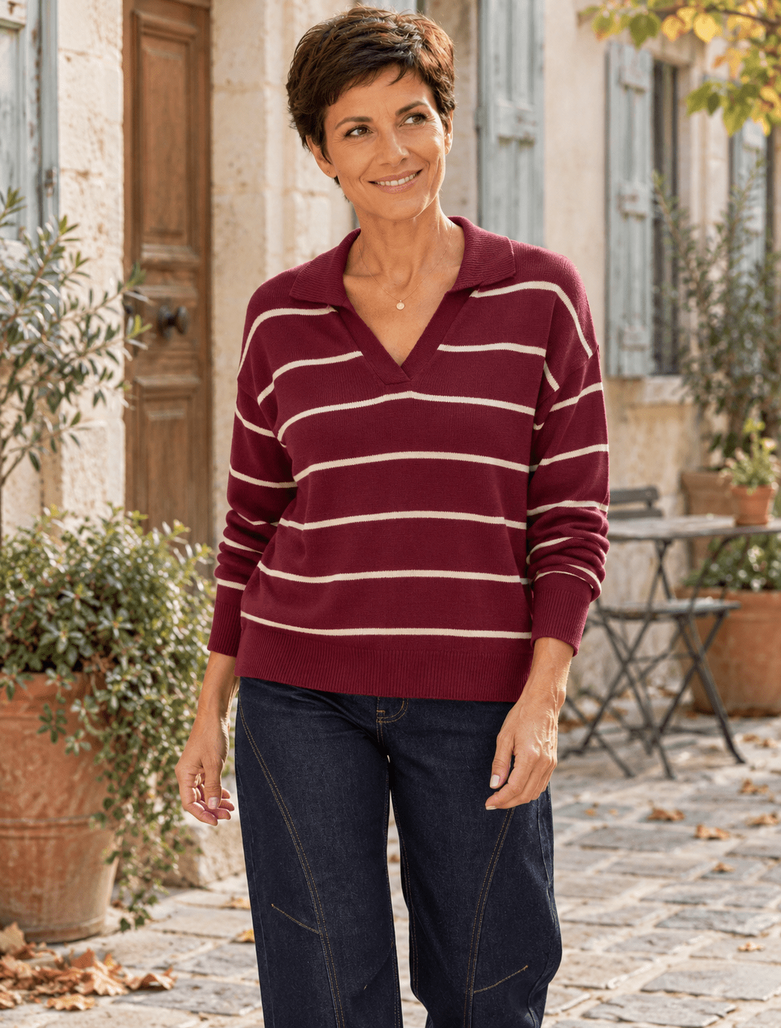 Pull marinière bordeaux à col polo ouvert porté par Sofia avec le jean Barrel bleu brut