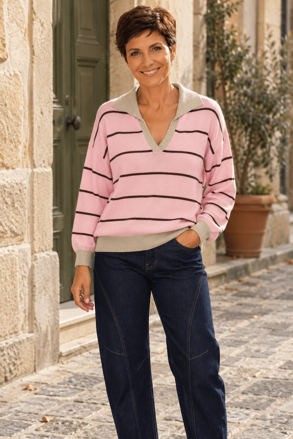 Pull marinière rose à col polo beige porté par Sofia avec le jean Barrel bleu brut