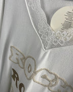 Détail du col dentelle et motif pailleté “ROCK” sur fond doux.